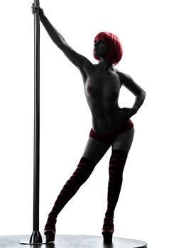 one caucasian woman pole dancer dancing in silhouette studio isolated on white background