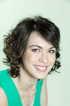 studio shots portrait of a beautiful caucasian young smiling woman on green background