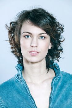 studio shots portrait of a beautiful caucasian young smiling woman on blue background