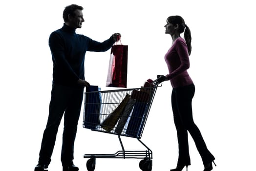 one caucasian couple woman man with shopping cart  and gifts in silhouette studio isolated on white background
