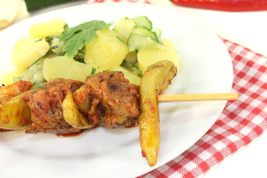 fresh Potato-cucumber salad with fire skewers on a light background