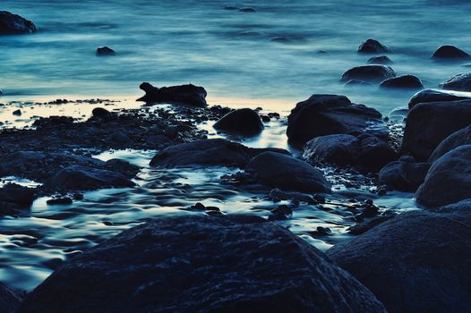 Blue boulders on the seashore in Arambol, Goa