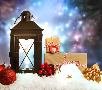 Christmas lantern with presents, ornaments and snow on a blue shinning background