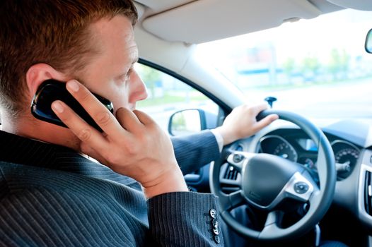 male businessman talking on a cell phone while driving