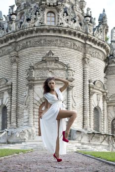 Sexy woman in a white dress on a background of the church