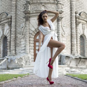 Sexy woman in a white dress on a background of the church