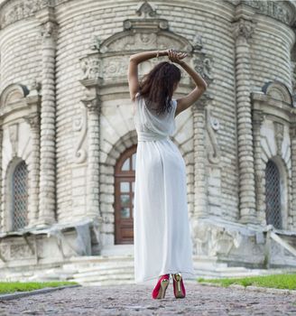 Sexy woman in a white dress on a background of the church