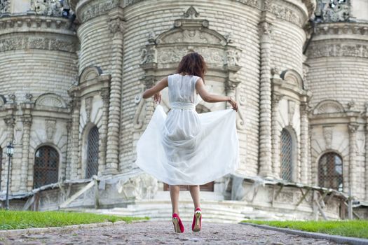 Sexy woman in a white dress on a background of the church