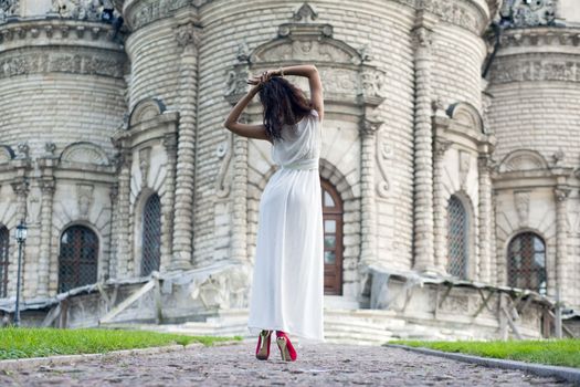 Sexy woman in a white dress on a background of the church