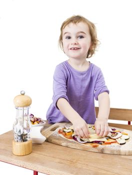 cute girl making pizza with a smile. isolated on white background