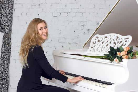 beautiful young woman playing the white piano