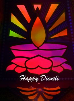 A design of traditional Diwali lamp pattern lit colorfully by backdrop for wishes of Diwali festival