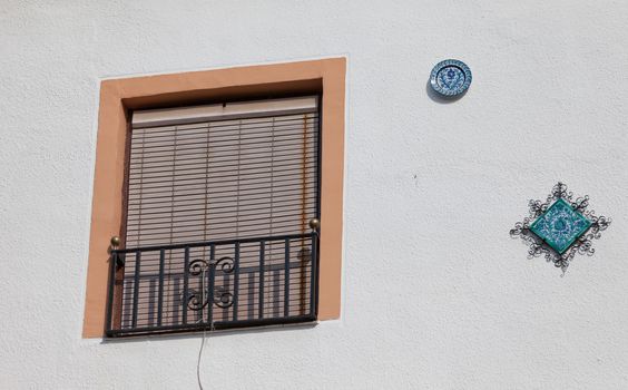 Wall with a window and decorative plates, Granada, Spain
