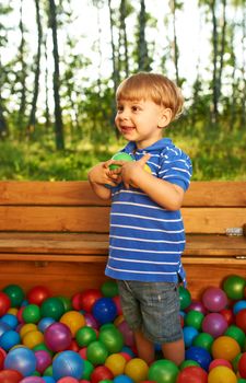 Happy child playing at colorful plastic balls playground high view