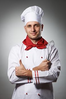 Male chef with thumb up portrait against grey background