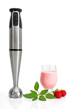 Hand blender and a glass of strawberry milkshake.