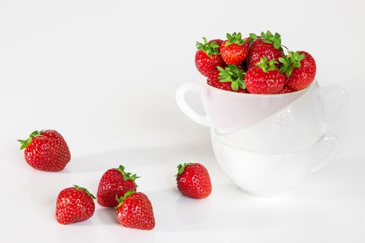 Fresh strawberries in a cup, on white background.