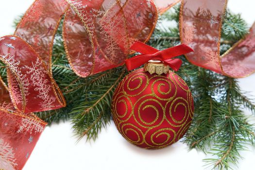 Christmas red ball, twig of fir , ribbon with drawing of tree ana star