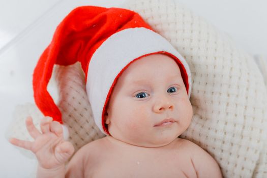 Christmas theme. Portrait of baby boy in a Santa hat in studio