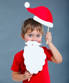 Christmas concept. Smiling funny boy in Santa red hat in studio.
