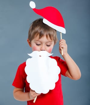 Christmas concept. Smiling funny boy in Santa red hat in studio.