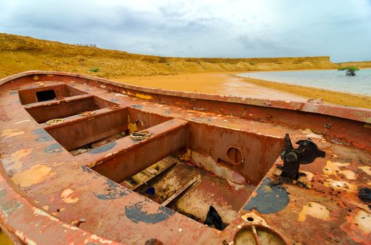 Old red boat and desert landscape in La Guajira, Colombia