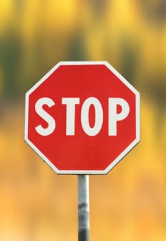 traffic red stop sign over beautiful faded autumn background