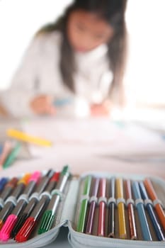 young child writting , painting and playing with colours (chinese child)