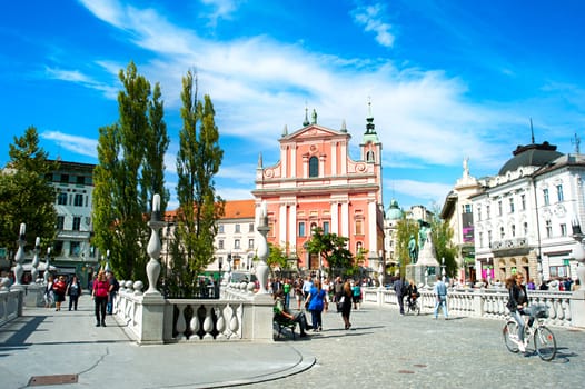 Ljubljana, Slovenia - September 2, 2013 : People walking at Triple Bridge and Preseren Square in Ljubljana, Slovenia. This year the city of Ljubljana is competing for the title of European Green Capital 2016.