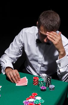 Gentleman in white shirt, playing cards, on black background