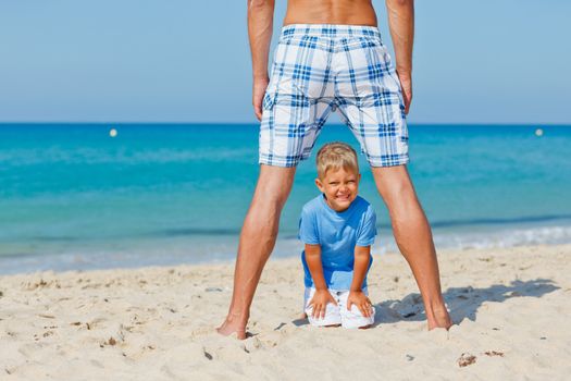 Father and son relaxing on beach holiday