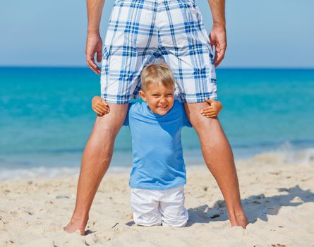 Father and son relaxing on beach holiday