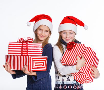 Christmas theme - Two smiling girl in Santa's hat with gift box, isolated on white