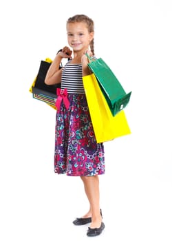 Shopping little girl happy smiling holding shopping bags isolated on white background.