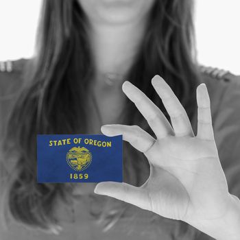 Woman showing a business card, black and white, Oregon