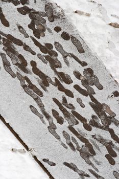 footprints at a snowy sidewalk