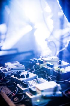 Guitar Pedals on a Stage with Live Band Performing During a Show. Low light image with copyspace