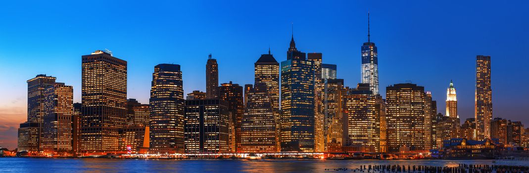 Manhattan. Night New York City skyline panorama with lights and reflections.