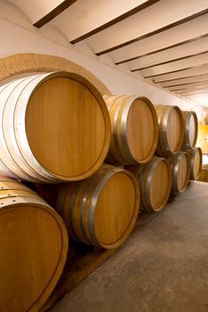 wine wooden oak barrels stacked in a row at Mediterranean winery