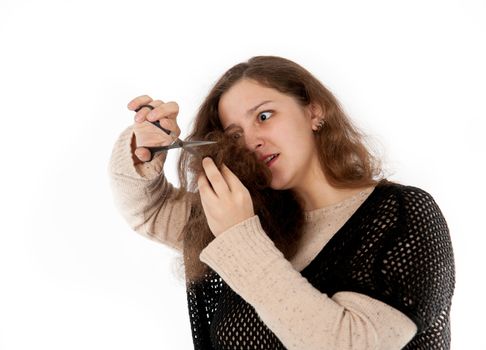 woman mows split ends of hair with scissors