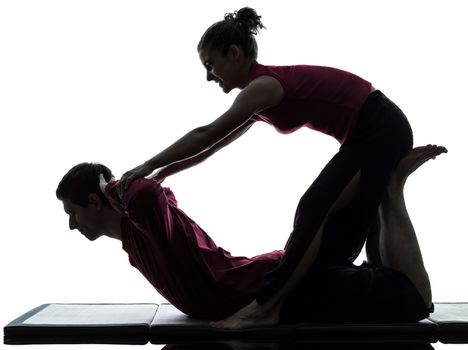 one man and woman performing thai massage in silhouette studio on white background