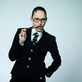 studio shot portrait of one business  woman thinking chewing pen