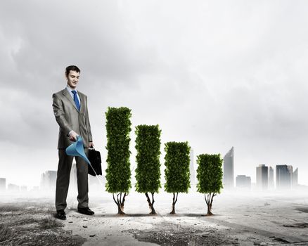 Image of businessman watering plant shaped like graph