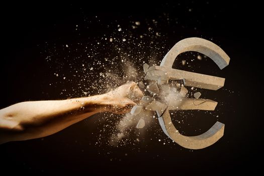 Close up image of human hand breaking euro stone symbol