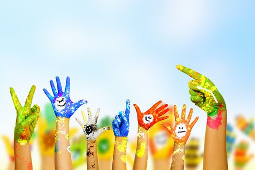 Image of human hands in colorful paint with smiles