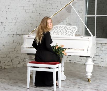 beautiful young woman playing the white piano