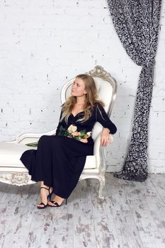Beautiful blonde woman in dress in luxury interior.