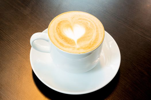 Cup of latte coffee with heart symbol