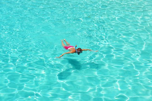 Man snorkeling in crystal clear turquoise water at tropical beach