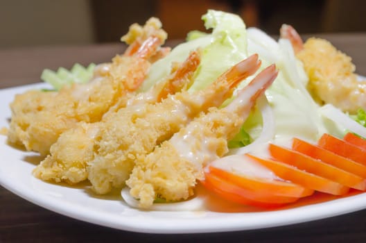 close up of deep fried shrimp and  fresh vegetable salad 